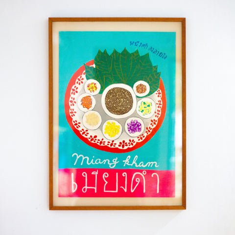 Framed artwork of a colorful dish with text on a white wall